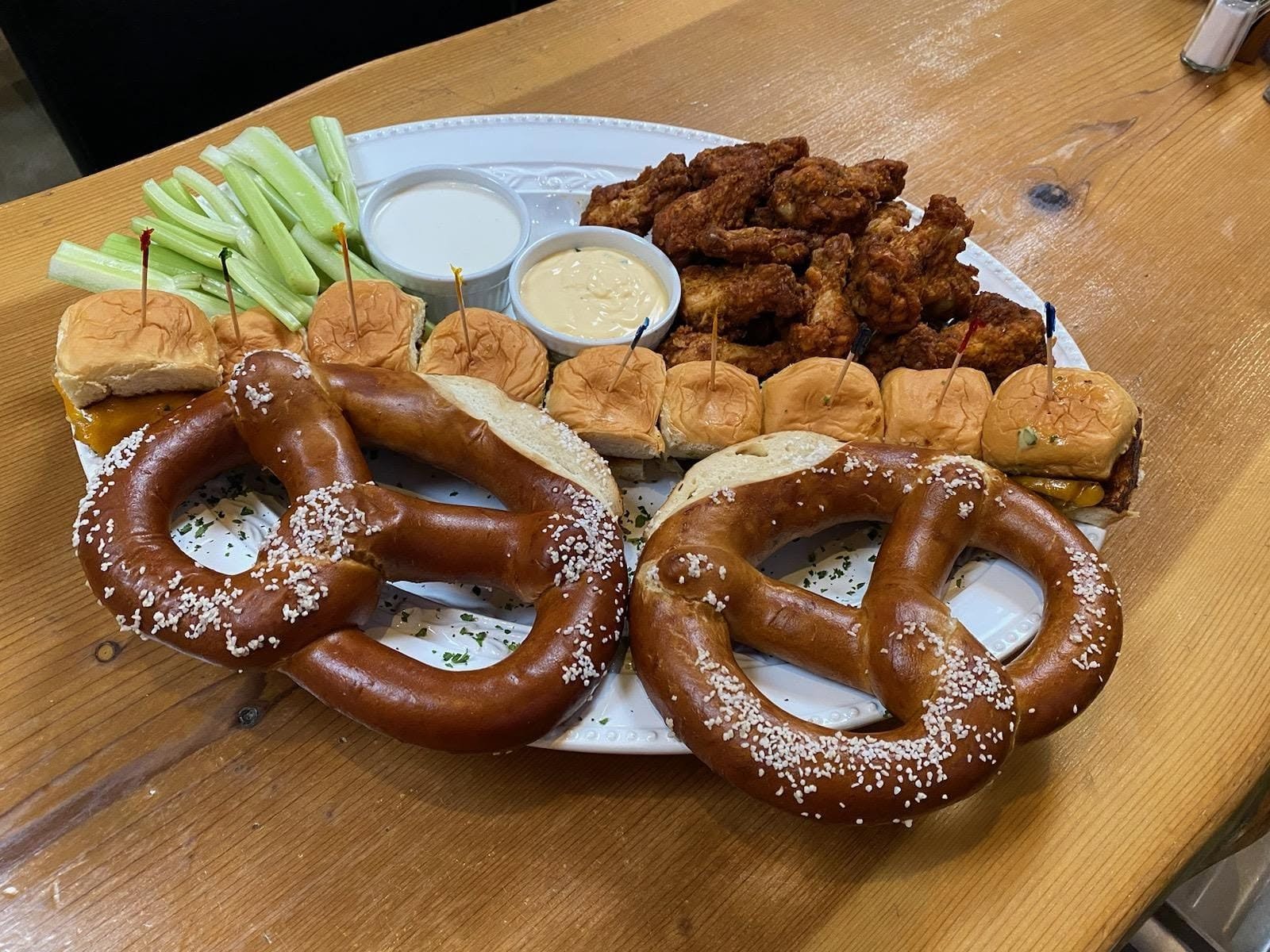 Shareable platter with soft pretzels, wings and sliders